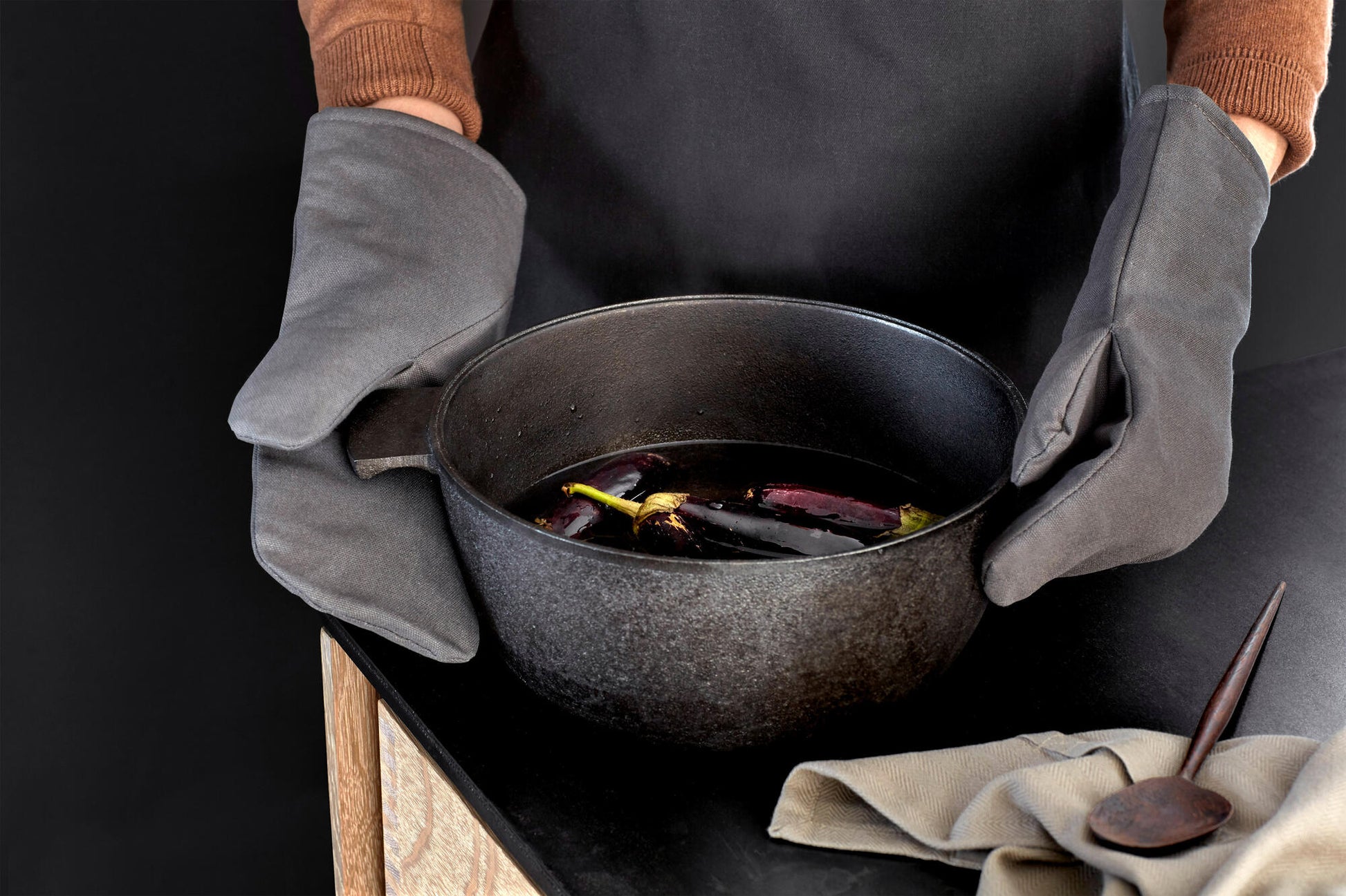 Person wearing Grey Organic Company Oven Mitts handling large pot